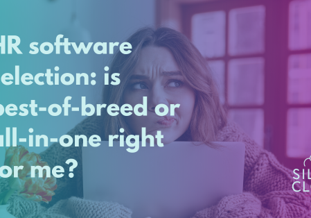 a woman peering over a laptop deciding between a best-of-breed or all-in-one approach
